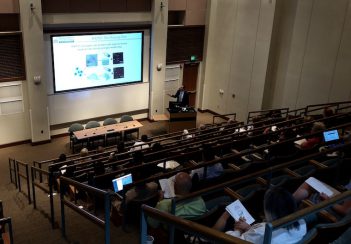 Participants sit in an auditorium while watching the second-annual iTHRIV Scholars Clinical Translational Research Symposium.
