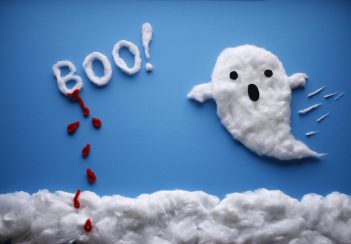 A cute ghost made of cotton fluff appears against a blue background. 
