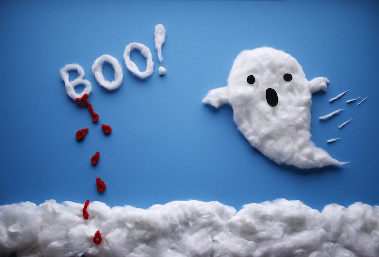 A cute ghost made of cotton fluff appears against a blue background. 