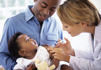 A female doctor administers a vaccine to a small child.