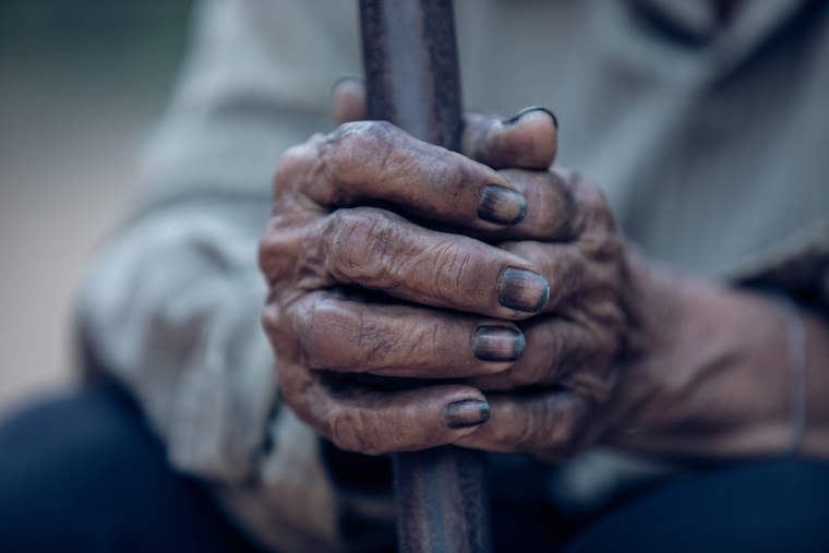 This is a closeup of a man's hands blackened by coal dust.
