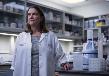 Dr. Amy Mathers wears a white coat in a lab.