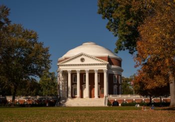UVA's Rotunda on a pretty day. The surrounding foliage is full and green.