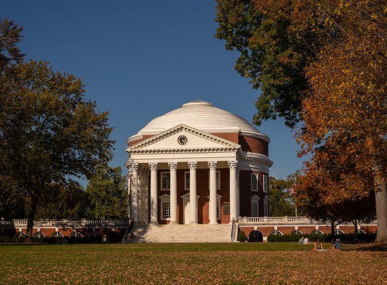 UVA's Rotunda on a pretty day. The surrounding foliage is full and green.