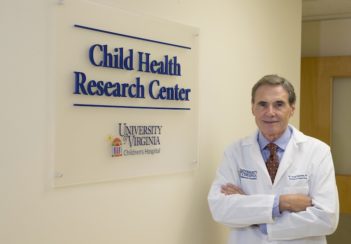Dr. Ariel Gomez stands next to the sign for UVA's Child Health Research Center.