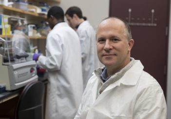 Jason Papin wears a white coat in his lab.
