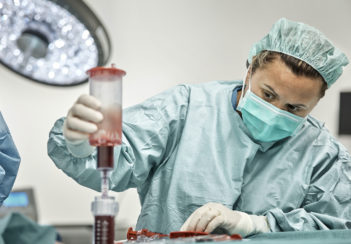A female doctor filtrates bone marrow before processing it.