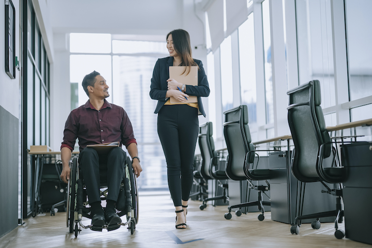 A person uses a wheelchair in a workplace.