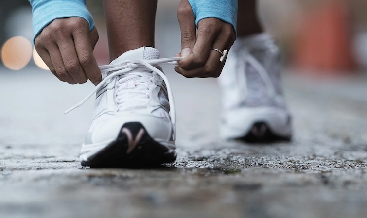 A runner ties her shoes