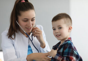 Pediatrician listening to child's lungs